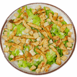 Prato com Salada Caesar, mostrando alface romana, tiras de frango grelhado e croutons, sobre uma toalha listrada vermelha e branca.