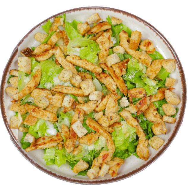 Prato com Salada Caesar, mostrando alface romana, tiras de frango grelhado e croutons, sobre uma toalha listrada vermelha e branca.